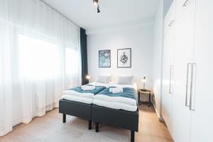 ein Schlafzimmer mit einem großen Bett mit blauer Bettwäsche in der Unterkunft Forenom Aparthotel Helsinki Pikku Huopalahti in Helsinki