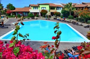 a pool at a resort with flowers at Porto Antigo Top 10 in Santa Maria