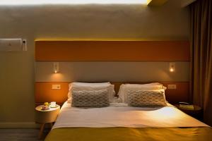 a bedroom with a large bed with two pillows at Hotel Apartamento Bajamar in Las Palmas de Gran Canaria
