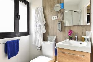 a bathroom with a toilet and a sink and a mirror at Hotel Apartamento Bajamar in Las Palmas de Gran Canaria