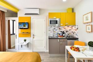 a kitchen with yellow cabinets and a table with a bowl of fruit at Hotel Apartamento Bajamar in Las Palmas de Gran Canaria