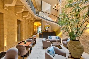 a lobby with chairs and tables and a staircase at 66 Saint Paul's & Spa in Valletta