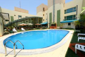 a large swimming pool in front of a building at Eastyard Dammam Hotel in Dammam