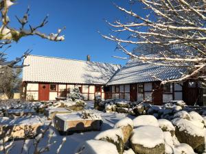 une maison recouverte de neige dans la cour dans l'établissement Kattalängan, à Brösarp