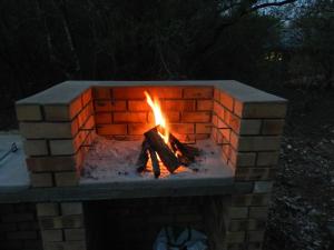 a brick fireplace with a fire in it at BUFFALO in Marloth Park