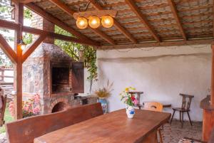 an outdoor dining room with a stone fireplace at Nad Rumianem in Rybno