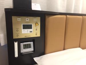 Habitación con cama y reloj en la pared en APA Hotel Ibaraki Koga Ekimae, en Koga