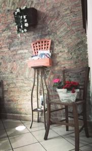 uma mesa e uma cadeira ao lado de uma parede de tijolos em B&B Garibaldi em Catânia