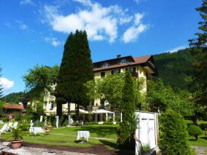 un complejo con un árbol y un edificio en Strandhotel Prinz, en Ossiach