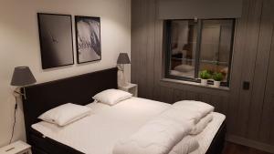 Schlafzimmer mit einem Bett mit weißer Bettwäsche und Kissen in der Unterkunft Fjällhem in Sälen