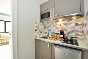 a kitchen with a sink and a microwave at Hotel Apartamento Bajamar in Las Palmas de Gran Canaria