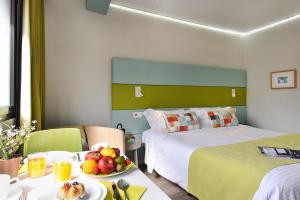 a hotel room with two beds and a bowl of fruit on a table at Hotel Apartamento Bajamar in Las Palmas de Gran Canaria