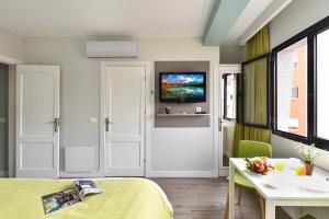 a room with a bed and a table and a tv at Hotel Apartamento Bajamar in Las Palmas de Gran Canaria