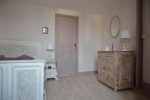 a white room with a wooden cabinet and a mirror at Le Tacot in Pont-de-Poitte