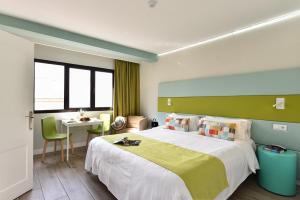 a bedroom with a large bed and a table at Hotel Apartamento Bajamar in Las Palmas de Gran Canaria