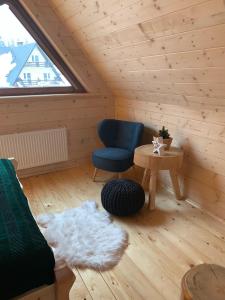 a living room with a blue chair and a table at Dadejówka Zakopane in Zakopane