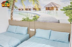 two beds in a room with a view of the beach at H2H - Summer Holidays Majestic Ipoh in Ipoh