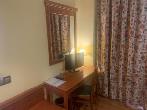 a wooden desk with a lamp on top of it at Hotel Camino Real in Arcahueja