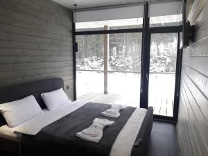 a bedroom with a bed with towels on it at The Living in Tatariv +156 photos
