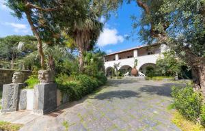 a building with trees and a stone walkway at B&B Villa Regine camera con terrazza a Forio in Forio d'Ischia