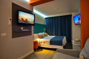 a hotel room with a bed and a flat screen tv at Hotel Apartamento Bajamar in Las Palmas de Gran Canaria