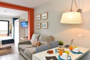 a living room with a table and a couch at Hotel Apartamento Bajamar in Las Palmas de Gran Canaria