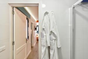 a bathroom with white towels hanging on a glass door at Hotel Apartamento Bajamar in Las Palmas de Gran Canaria