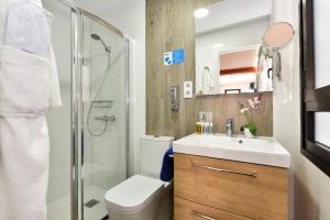 a bathroom with a toilet and a sink and a shower at Hotel Apartamento Bajamar in Las Palmas de Gran Canaria