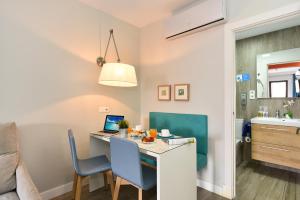 a room with a desk with a laptop and chairs at Hotel Apartamento Bajamar in Las Palmas de Gran Canaria
