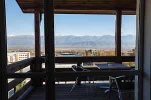 a balcony with a table and a view of the mountains at Alazani Valley Hotel in Tʼelavi