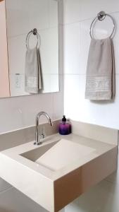 a white kitchen with a sink and a mirror at Pousada Sempre Viva in São João Batista do Glória