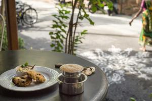 a table with a plate of food on it at Maison Perumal Pondicherry - A CGH Earth Experience in Pondicherry