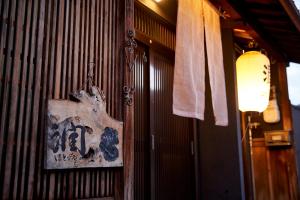 un cartello sul muro di un ristorante di 1日1組のお客様を御迎えする宿Hotobil An inn that welcomes one group of guests per day a Nara