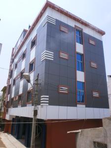 een blauw gebouw met rode en witte ramen bij Blue Moon Residency in Mysore