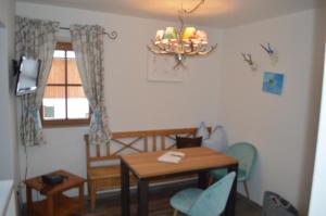 ein kleines Zimmer mit einem Tisch, einem Tisch und Stühlen in der Unterkunft Gästehaus Baier am Bad in Bad Wiessee