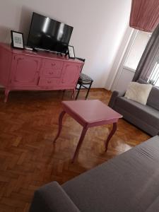 ein Wohnzimmer mit einer rosa Kommode und einem TV in der Unterkunft Belgrade Base in Belgrad