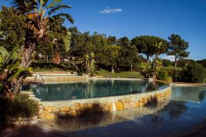 a swimming pool with a stone wall around it at Apartments Maria - Balaia 702 in Albufeira