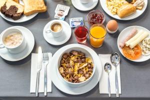 a table with a bowl of food and other breakfast foods at Empire Lisbon Hotel in Lisbon