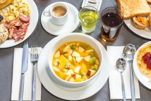 una mesa con un tazón de sopa y platos de comida en Empire Lisbon Hotel en Lisboa