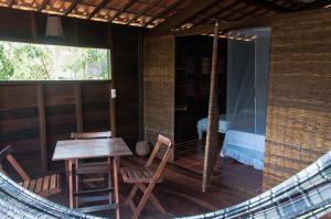 a room with a table and chairs and a swing at Jangada Lodge in São Miguel do Gostoso