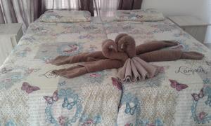 a stuffed animal on a bed with butterflies on it at Elegant Guest House Malelane in Malelane