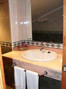 a bathroom with a sink and a mirror at Hotel Camino Real in Arcahueja