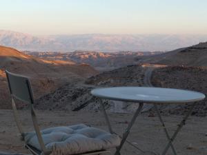 a table and a chair with a table and a view at Dead Sea Desert's Edge in Arad