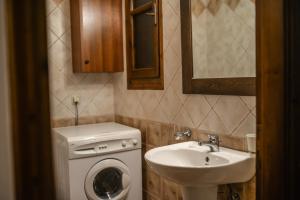 a small bathroom with a washing machine and a sink at Anna Apartments in Lithakia +17 photos