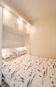 a bedroom with a bed with a white comforter at Appartement Zeezicht in Ostend