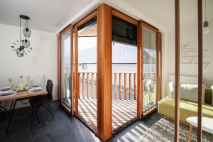 a room with a balcony with a desk and sliding glass doors at Apartment Amber, Kranjska Gora - Center in Kranjska Gora