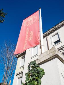 una bandiera rossa sul lato di un edificio di Hotel Regina Margherita a Roma