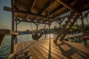 a wooden dock with a hammock on the water at Casa Nostra in Lívingston