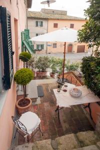 an outdoor patio with a table and an umbrella at Appartamenti La Rocca in Palaia