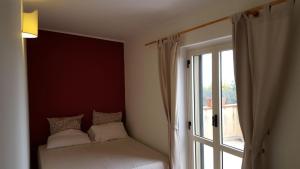 a room with a window with a bed next to a door at Villa "Il Giardino di Rocco" in Badolato